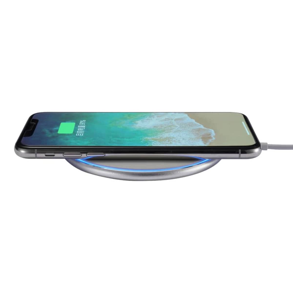 A smartphone is placed on a round wireless charging pad. The phone screen displays a charging icon with a green battery, indicating it is charging. The charging pad has a glowing blue ring around its edge.