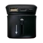 A black travel adapter with a USB-A port, a USB-C port, a power button, and a UK plug. The adapter has an arrow indicating which direction to slide or adjust the plug.