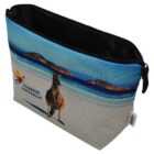 A zippered pouch with a scenic beach print featuring a kangaroo and waves. The pouch has a Tourism Australia logo on the front, with blue sky and ocean in the background.