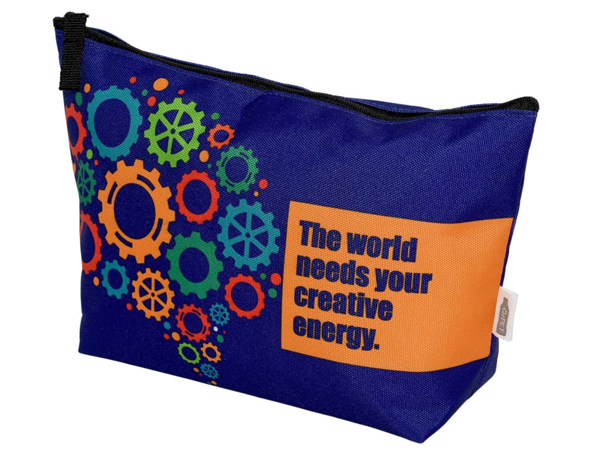 A blue zippered pouch with colorful gear designs and the words The world needs your creative energy on an orange rectangle.