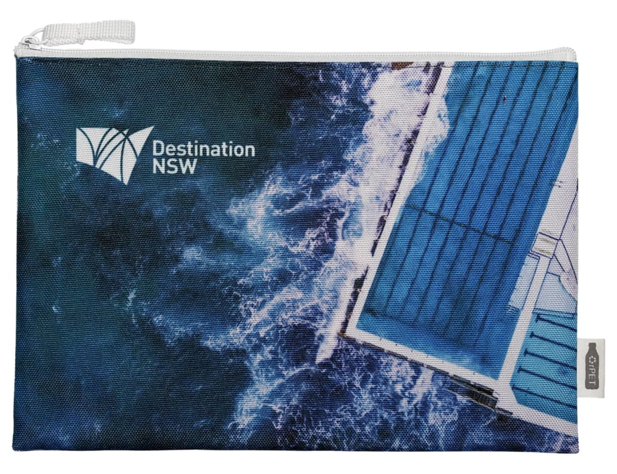 A zippered pouch featuring an aerial view of ocean waves crashing against a pool. The text Destination NSW is visible on the upper left corner of the pouch.