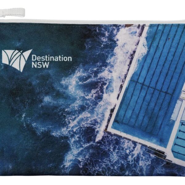 A zippered pouch with a design featuring an aerial view of ocean waves crashing against a rectangular pool. The Destination NSW logo is printed on the left side.