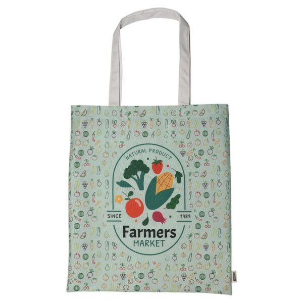 A reusable shopping bag with a farmers market logo, featuring illustrations of vegetables like broccoli, tomato, corn, and radish. The background has a pattern of various small fruits and vegetables on a light green surface.