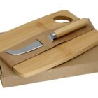 Wooden cutting boards and a cheese knife with a wooden handle on a cardboard box.