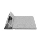 A gray, fabric-covered wireless charging pad with a triangular, stand-like structure at one end for holding devices upright. The circular charging area is visible on the pads surface.