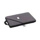 A sleek, gray laptop sleeve lying flat, featuring a small rectangular patch in the center and a black handle on the side. The sleeve has a zippered closure for securing the laptop inside.