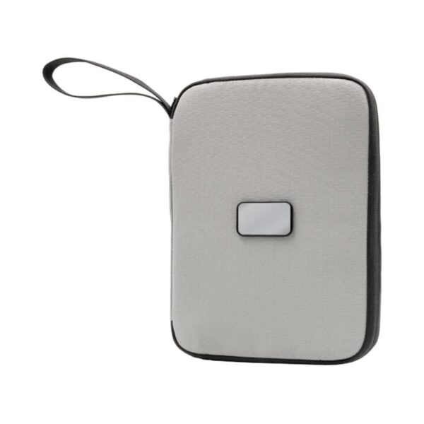 A gray fabric-covered electronic device with rounded edges and a small rectangular button on its surface. It features a black edge and a wrist strap for easy carrying.