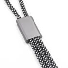 Close-up of a black and white braided cord threaded through a sleek, rectangular metal clasp, creating a simple yet stylish design.