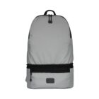 A gray backpack with a sleek design, featuring a black zipper and handle. It has a square patch on the lower front section and a smooth, rounded top.