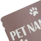 Close-up of a corner of a brown mat with white text partially reading PET NAM and featuring white paw print designs.