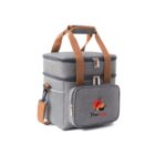 A gray insulated lunch bag with two compartments, featuring brown handles and a detachable shoulder strap. The front pocket displays a logo with a red circle and black text.