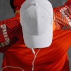 Person in a red shirt and white cap, wearing earphones, viewed from above.