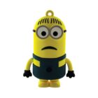 A cartoonish yellow character with round eyes, wearing goggles, black gloves, and a blue outfit stands facing forward. It resembles a popular animated film character and has a small loop on top, likely used as a keychain or USB cover.
