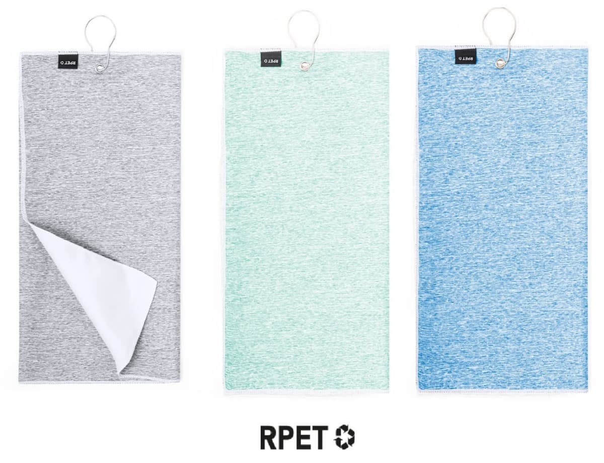 Three hanging towels are displayed side by side: gray, green, and blue. The gray towel is partially flipped, revealing a white underside. Below, RPET with a recycling symbol is visible.