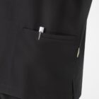 A close-up of a person wearing a black garment with a pocket. A pen is partially visible in the pocket. The fabric appears smooth and the overall appearance is professional.