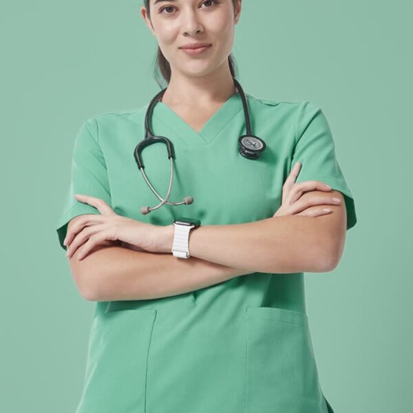 A healthcare professional in green scrubs stands with arms crossed, wearing a stethoscope around the neck. The background is a matching green color.