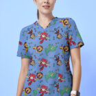 A person wearing scrubs with a playful pattern of colorful animals, including pandas, lions, and turtles, stands against a light blue background. They are smiling and have dark hair tied back.