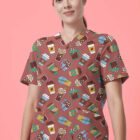 A person wearing scrubs with a coffee-themed pattern stands against a pink background. The scrubs are adorned with illustrations of coffee cups, to-go cups, and coffee beans. The person has long, dark hair tied back and is wearing a wristband.