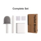 A complete toilet brush set including a brush with a silicone head, a handle, two adhesive wall mounts, a holder, and a brown cardboard box labeled Toilet Brush.