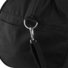 Close-up of a black fabric bag featuring a metal zipper and a clip fastened to a metal ring. The bags texture is visible, and the strap is attached to the metal clip.