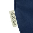 Close-up of a dark blue fabric with a visible tag that reads RECYCLED COTTON in black letters. The tag is cream-colored and positioned at the edge of the fabric.