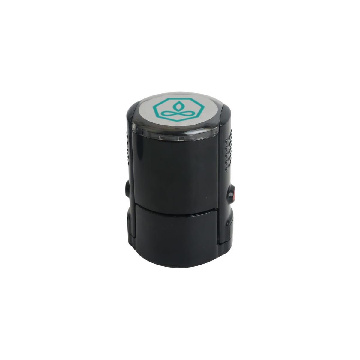 A black cylindrical self-inking stamp with a white top featuring a green abstract logo in the center. The stamp is seen upright against a plain white background.