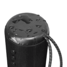 Water droplets on a black portable speaker with a carrying strap, viewed from above.