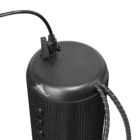 Black portable speaker with cord plugged in and carrying strap attached.