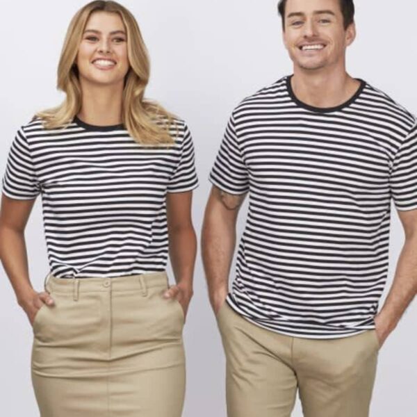 Two people smiling at the camera, both wearing black and white striped shirts. The person on the left is in a beige skirt, and the person on the right is in beige pants. They are standing against a plain white background.