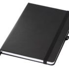 A plain black hardcover notebook with an elastic band closure, resting at an angle. The notebook has a fabric bookmark ribbon and appears to be closed. It has a minimalist design with slightly rounded corners.