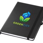 A black notebook with a colorful logo featuring blue geometric shapes resembling a building and green leaves beneath them. The text GREEN CITY is printed in green and blue below the logo. A black elastic band wraps around the notebook.