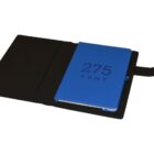 An open black leather notebook cover with a blue notebook inserted inside. The notebook cover is opened to the right, revealing the number 275 and the word KENT embossed on the front in large text.