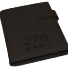 A black notebook with a strap closure, embossed with the numbers 275 and the word KENT on the cover.