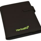 A black leather planner with a magnetic flap closure features the green Herbalife logo on the front.
