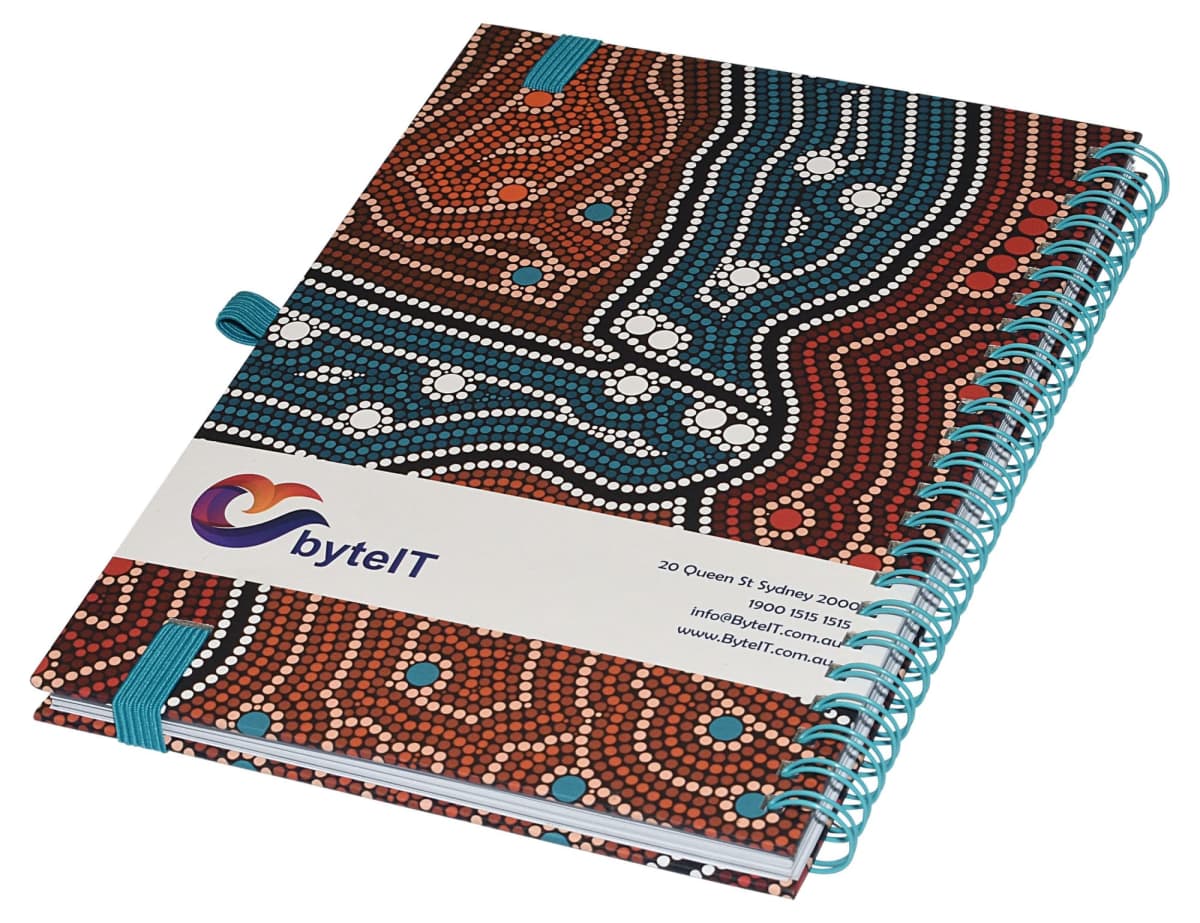 A spiral-bound notebook with a colorful, dotted pattern on the cover, featuring earthy tones of brown, orange, and white. A white band across the center displays contact details and a logo for byteIT with a stylized design.