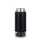A sleek black insulated water bottle with a transparent compartment at the bottom filled with small brown cubes. The bottle has a shiny, stainless steel lid and a modern design.
