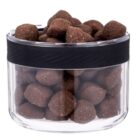 A transparent container with a black lid band holds round, brown dog kibble. The kibble pieces fill the container to the top.