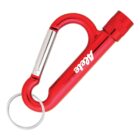 A red carabiner keychain with a built-in metallic pen. The carabiner has a spring-loaded gate and an attached circular keyring. The pen cap is secured with a twist mechanism.