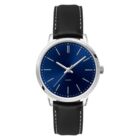 A wristwatch with a blue dial and minimalist design. It has a silver case, simple hour markers, and a black leather strap with white stitching. The word Quartz is visible on the dial.