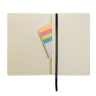 Open notebook with a black ribbon bookmark. Inside, there are colorful sticky notes in pink, orange, yellow, green, and blue. The pages are blank.