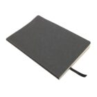 A black notebook with a plain cover lies closed, slightly tilted. The edges of the pages are visible, and a black ribbon bookmark is tucked inside.