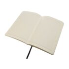 Open notebook with lined pages and a black ribbon bookmark, lying flat on a white background.