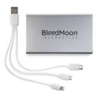 A silver portable charger with BloodMoon Interactive logo. Three white charging cables are attached: a USB, a micro USB, and a Lightning connector.