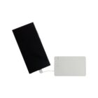 A black smartphone connected to a white power bank with a visible charging cable. The phones screen is off, and the power bank has a small LED light indicating power status.