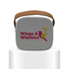 A square, gray Bluetooth speaker with a brown strap, featuring the Wings & Whistles logo and a stylized bird design in red and yellow. It is placed on a white cylindrical pedestal.