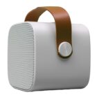 A white portable speaker with a brown leather handle, featuring a smooth exterior and a round silver knob on the side. The speaker grill is visible, and its modern design is highlighted against a white background.