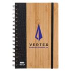 A bamboo notebook with a spiral binding and a black elastic band. The cover features a blue geometric logo and the text VERTEX Financial Solutions Inc. A small recycled material symbol is in the corner.
