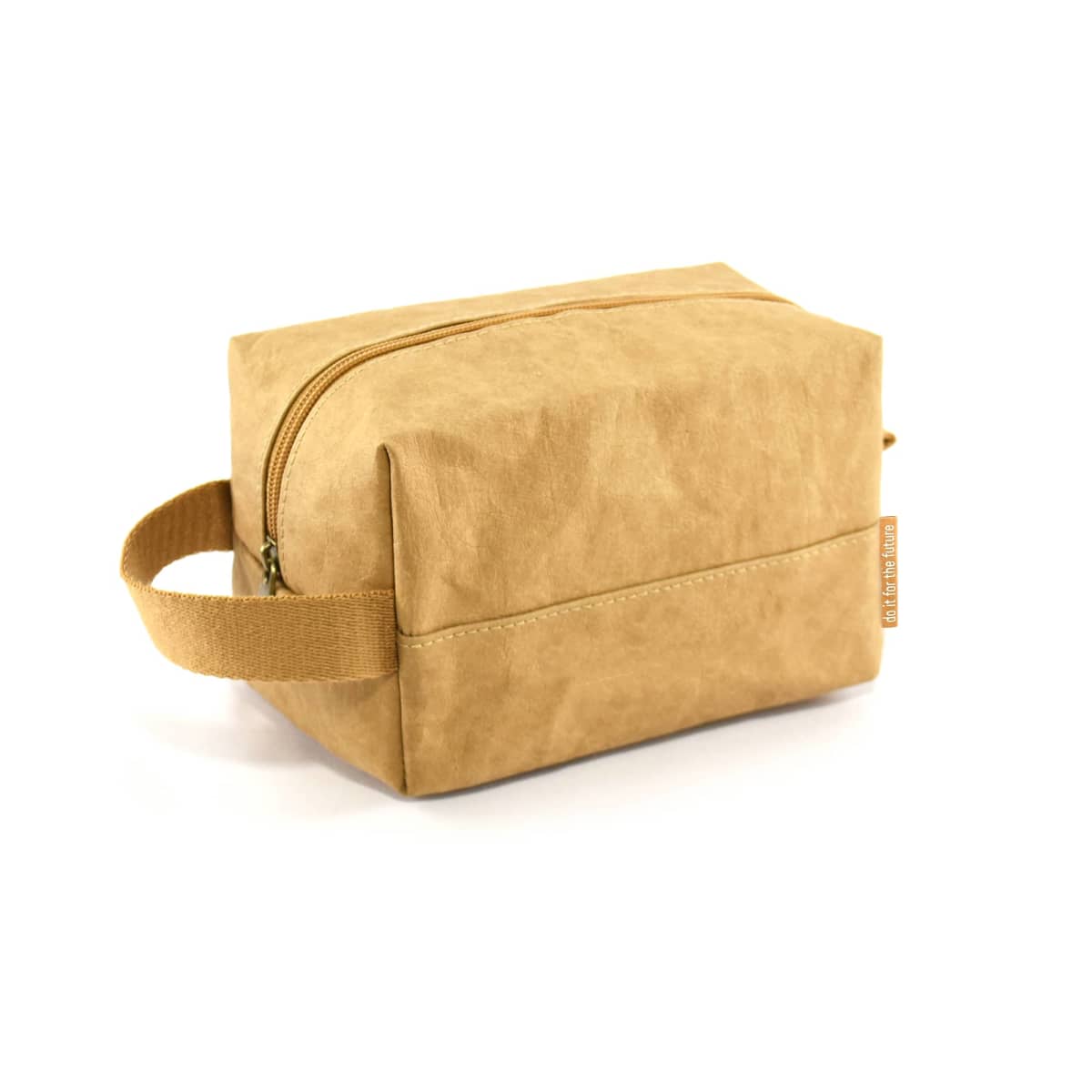 A rectangular, light brown toiletry bag with a zipper on top and a side handle. The material appears to be a soft, textured fabric. The bag is against a white background.