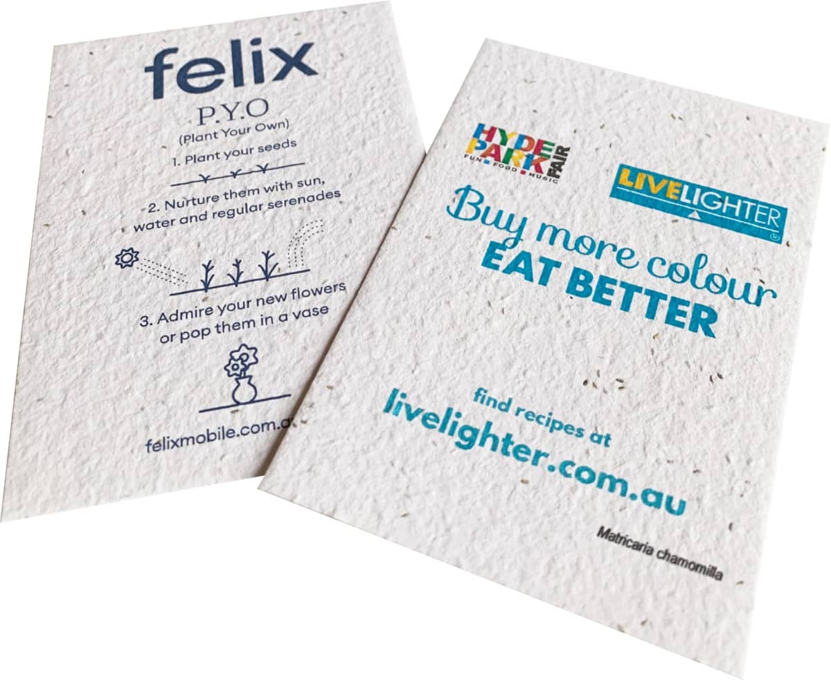 Two eco-friendly seed packets are displayed. The first features planting instructions for seeds with step-by-step guidance. The second promotes healthy eating with the slogan Buy more colour, EAT BETTER and includes a website link for recipes.