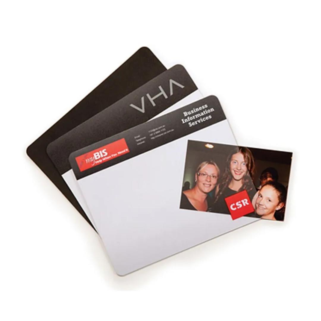 Three stacked folders labeled VHA and Business Information Services, along with a photo of three smiling individuals, rest on a Promotional Printed Lift Top Mouse Mat.